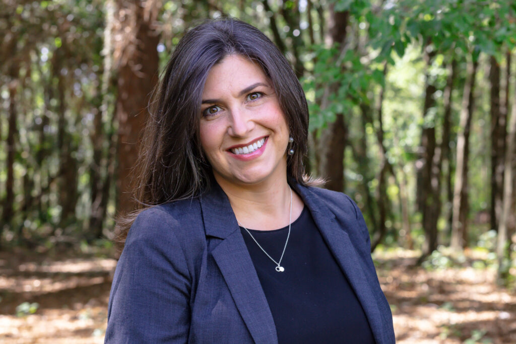 female headshot with woodsy background