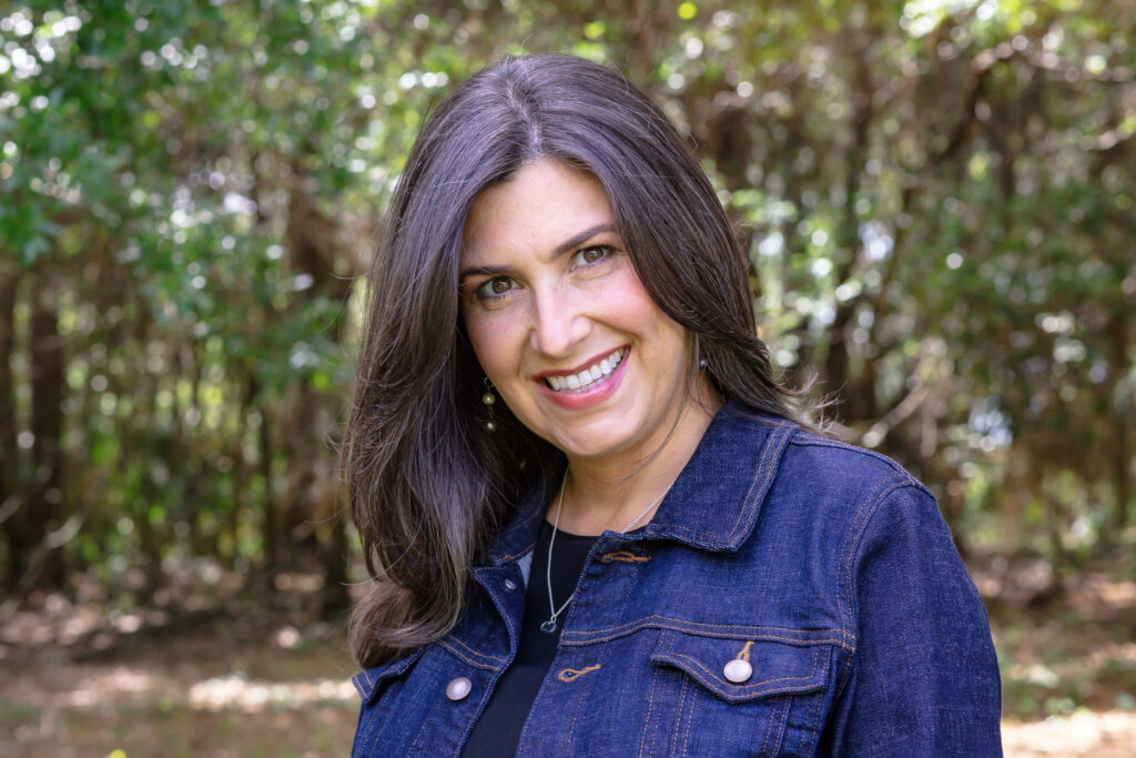 female headshot with woodsy background