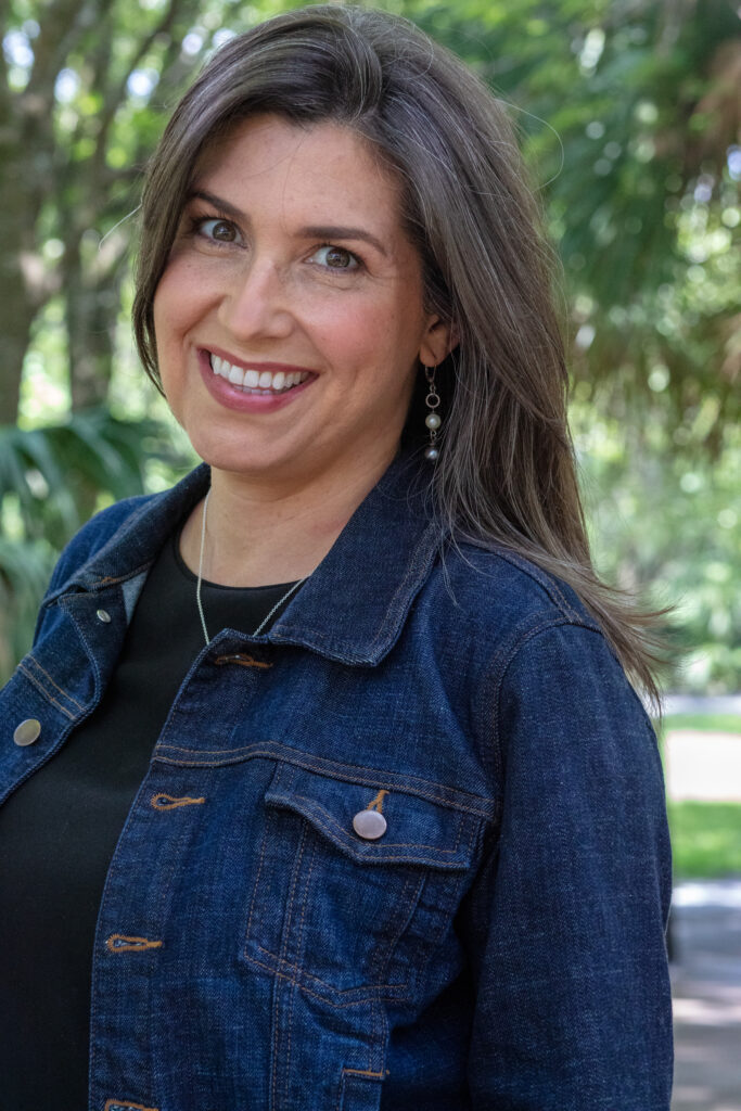 female headshot with woodsy background