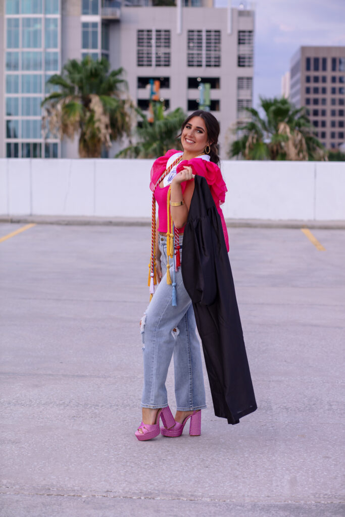 graduation girl with her cap and gown on top of a parking garage