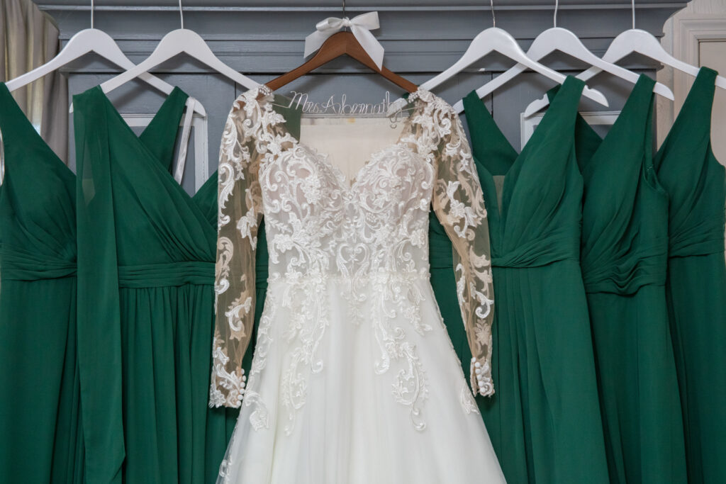Brides dress hanging with the bridesmaids dresses