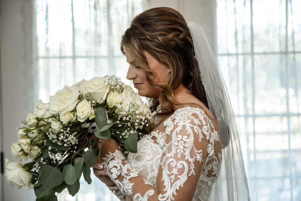 Bride smelling her flowers in her wedding dress