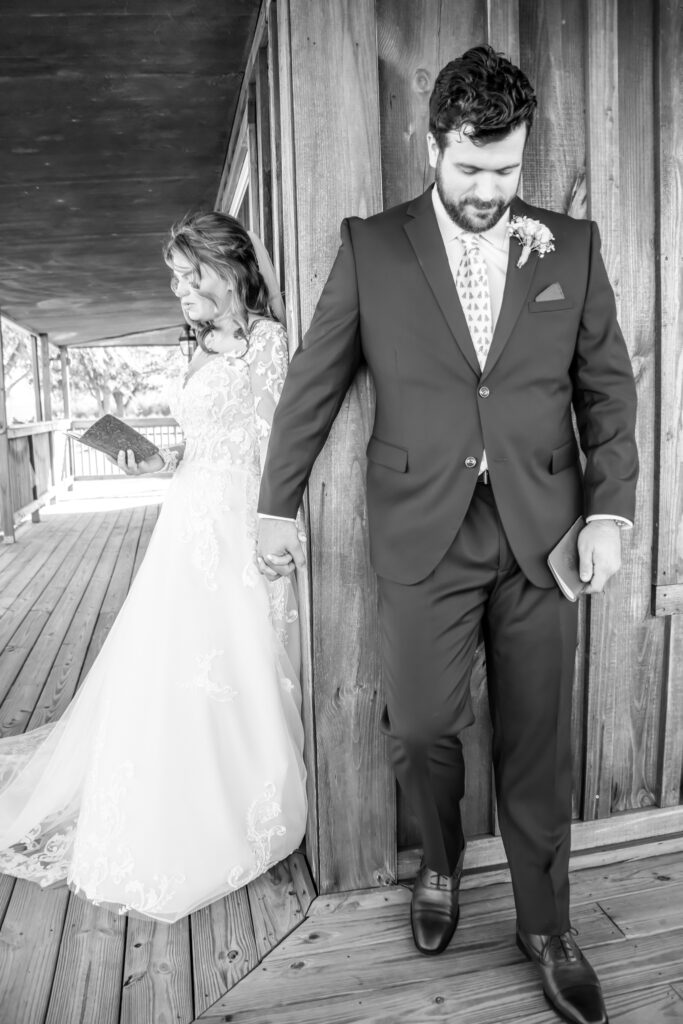 Bride and groom standing on the outside corner of the cottage saying their vows