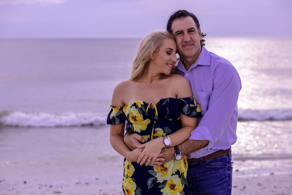 husband and wife hugging on the beach at sunset