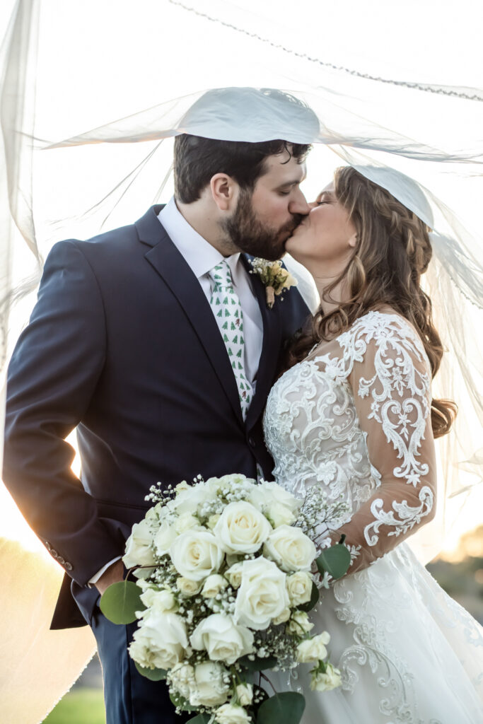Bride and groom kissing under the bride's veil