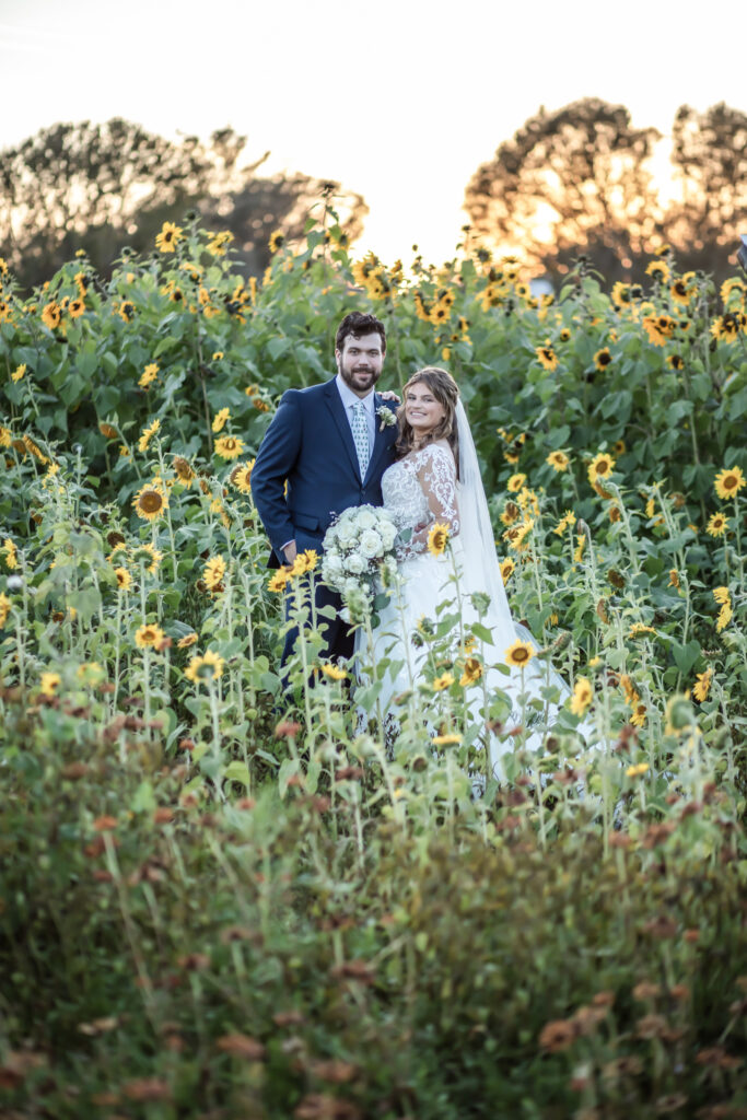 Bride and groom standing in the middle of a sunflower field