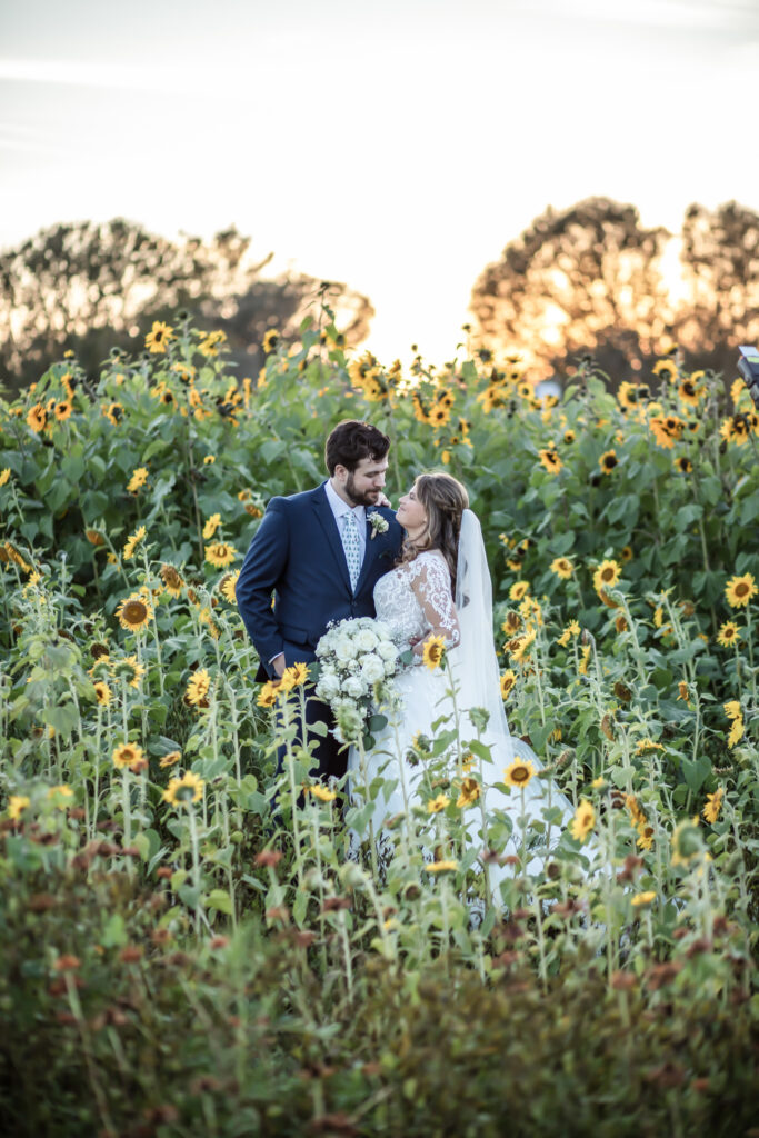 Bride and groom looking into each others eyes in the middle of a sunflower field