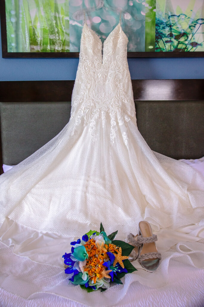 wedding dress hanging above the bed with brides flowers