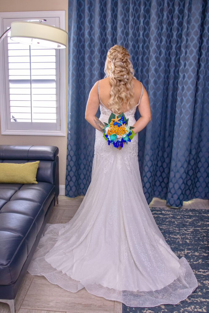 bride in her dress with her flowers, from the back