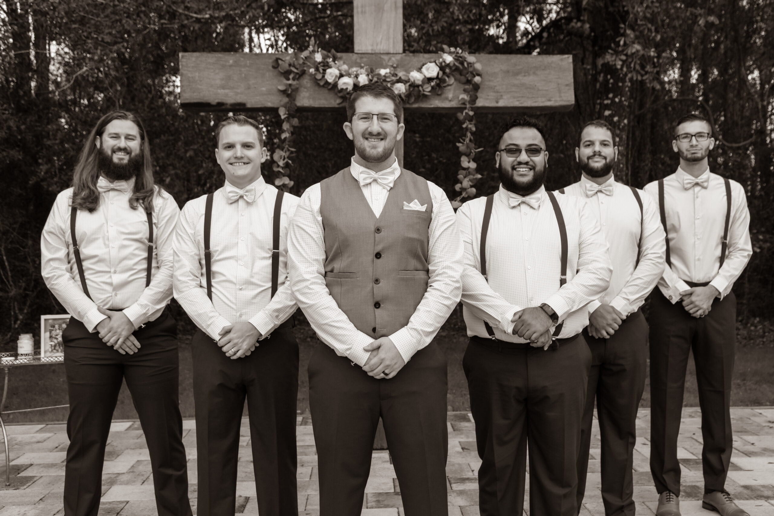 groom with groomsmen posing at the wedding ceremony altar, outdoors