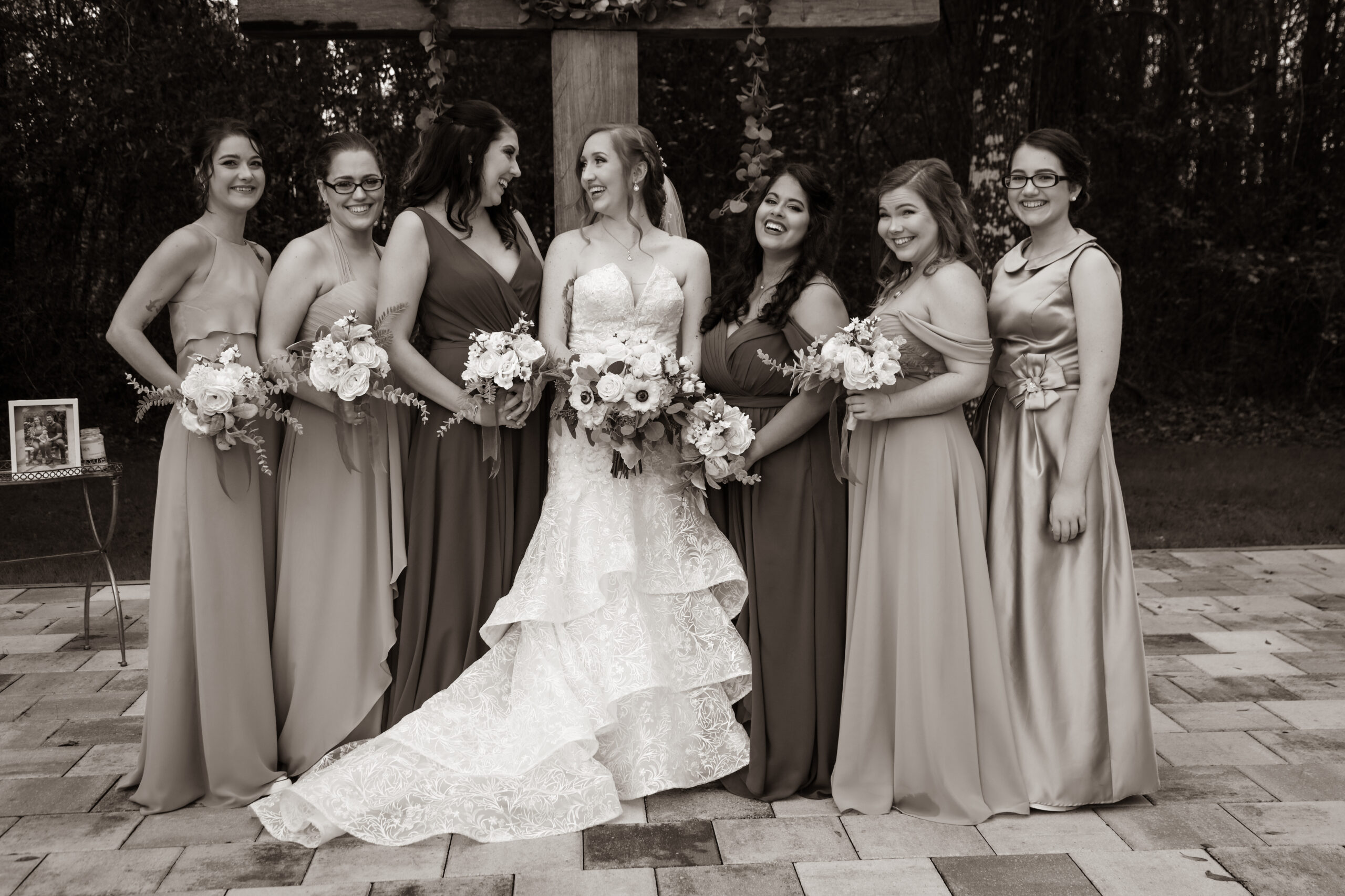 bride with bridesmaids posing at the wedding ceremony altar, outdoors