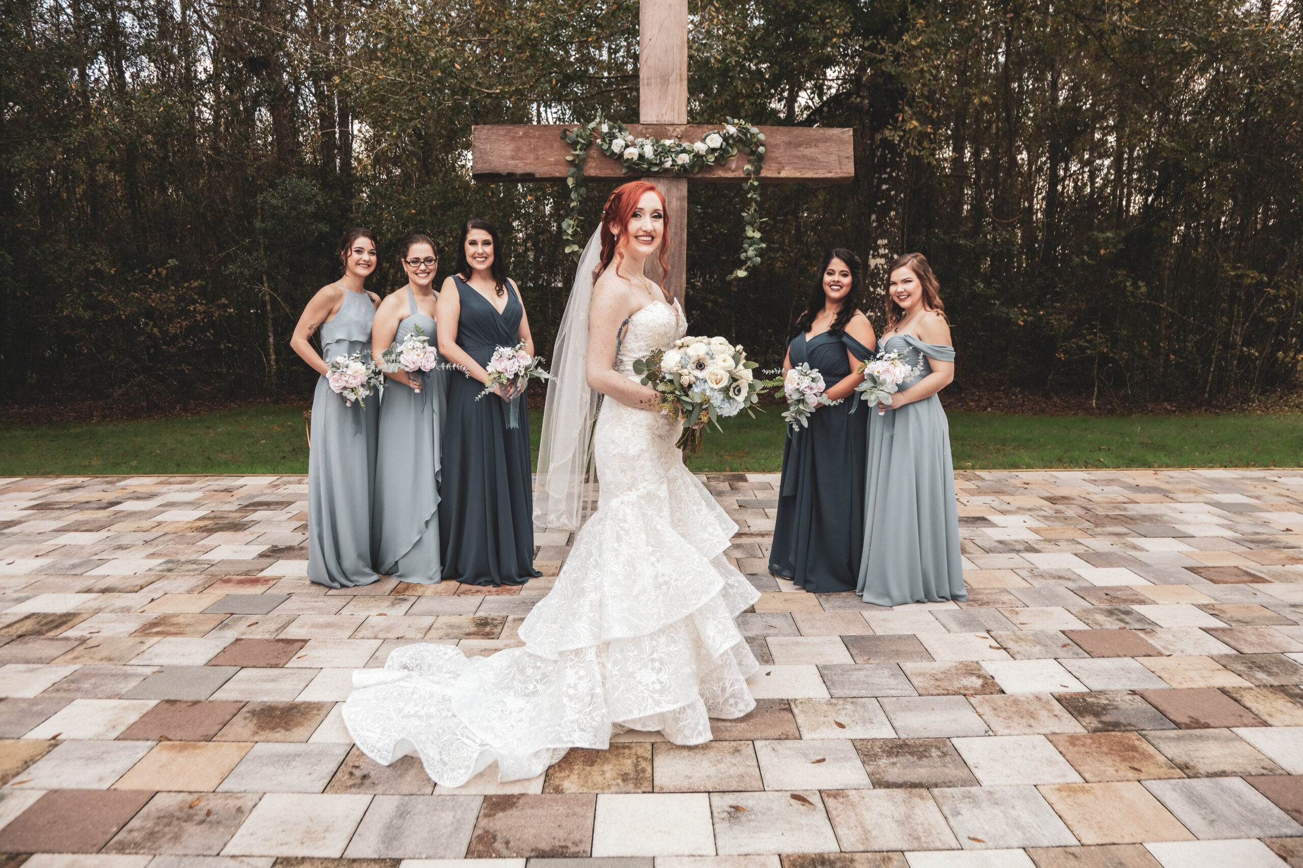 bride with bridesmaids posing at the wedding ceremony altar, outdoors