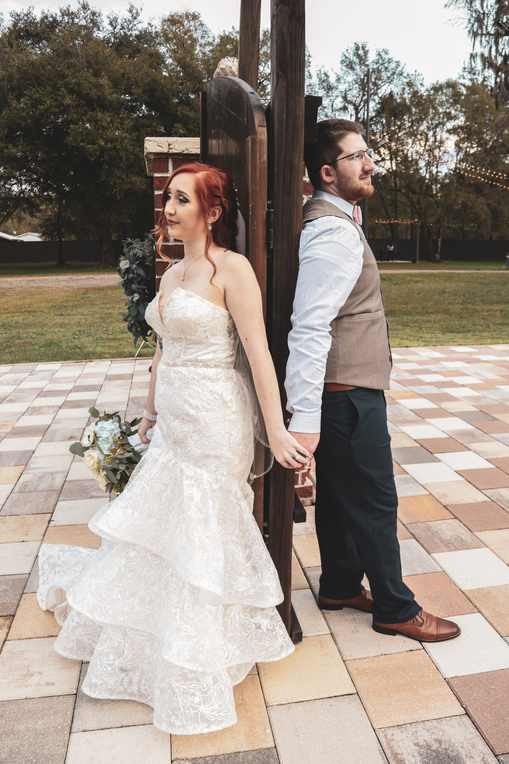 bride and groom holding hands on the opposite of wooden ceremony doors