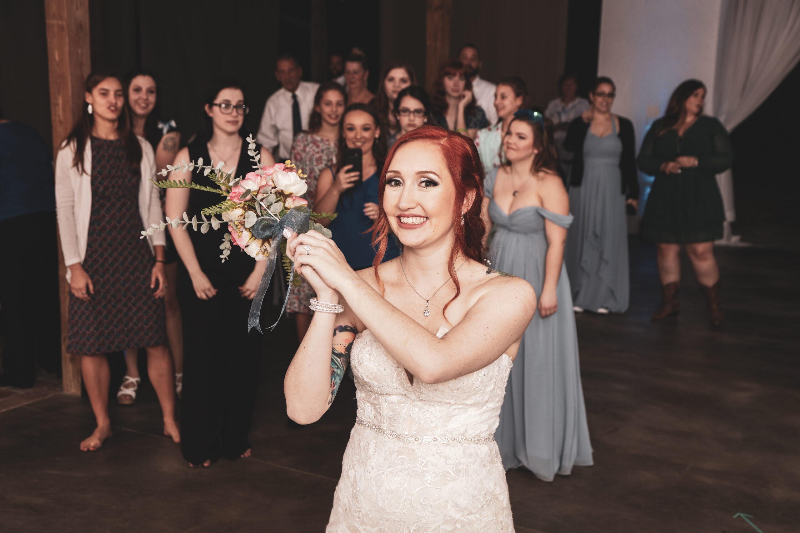 bride throwing her bouquet of flowers to bridesmaids