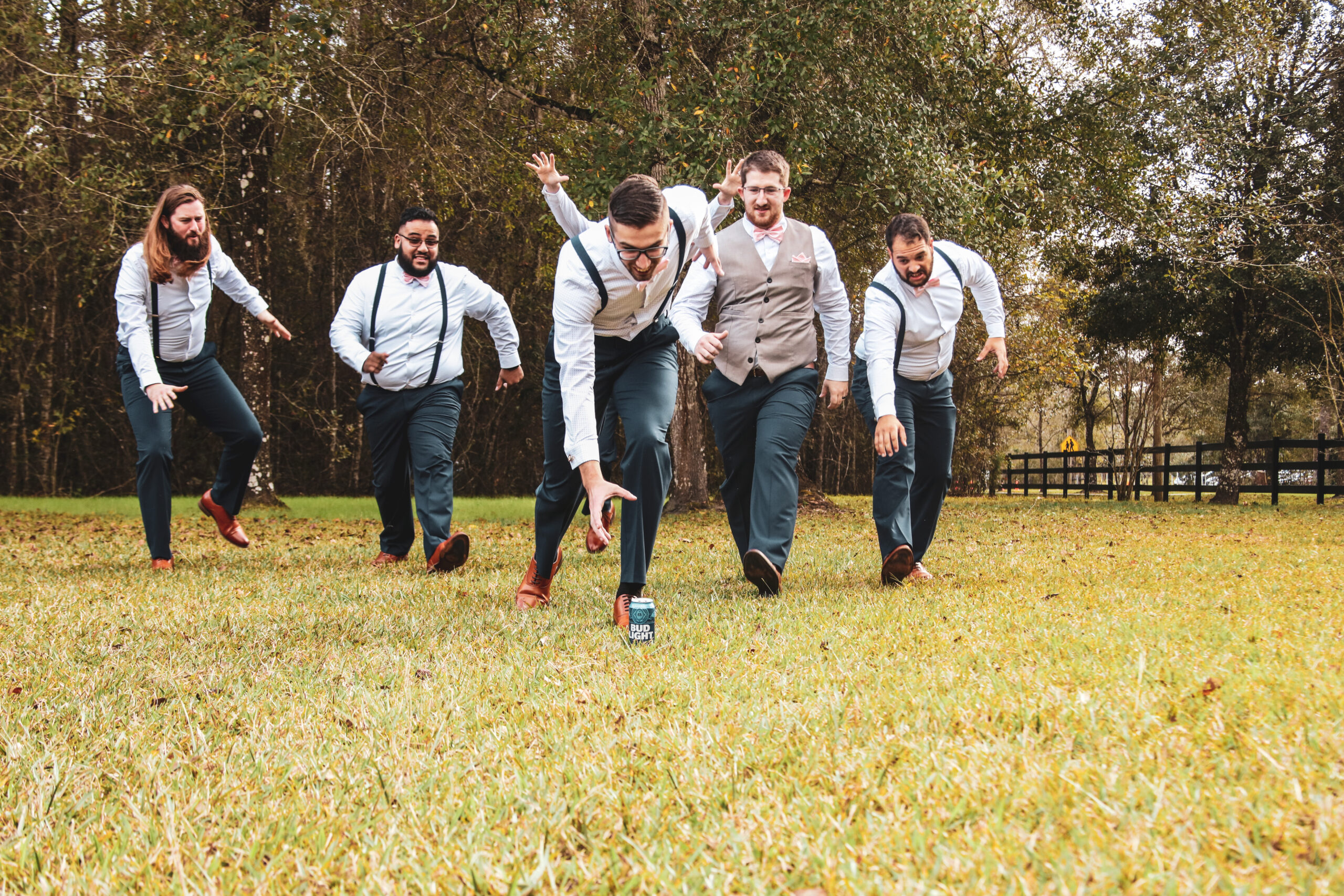 groom with groomsmen in a lawn running towards a beer can