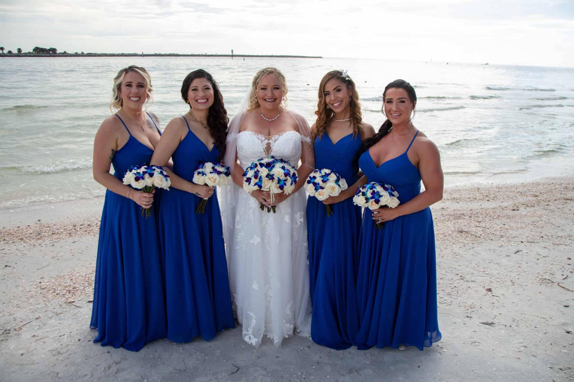 bride with her bridesmaids on the beach