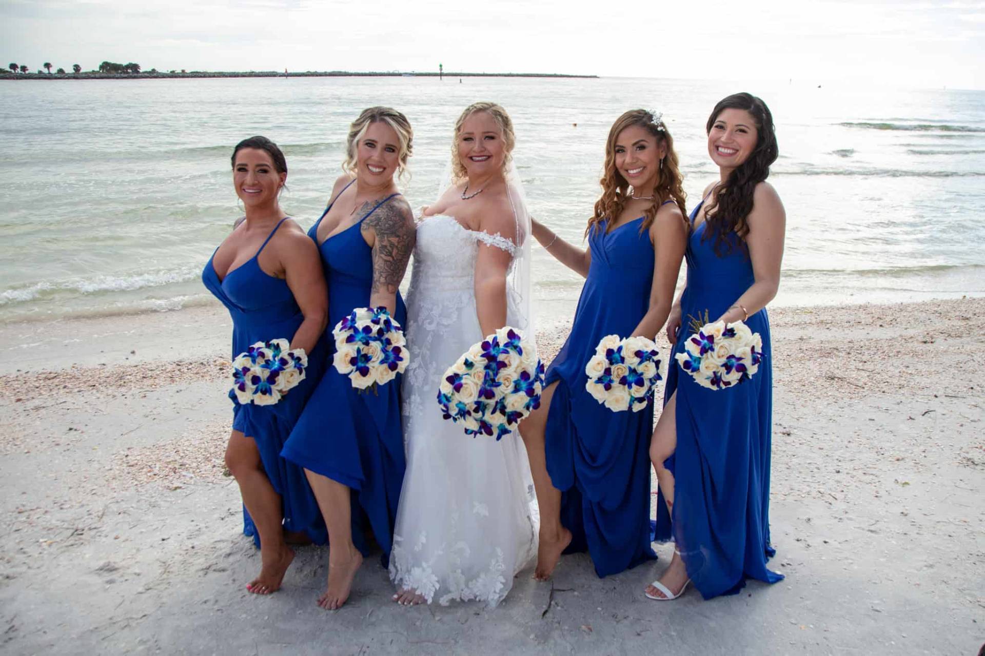 bride with her bridesmaids on the beach