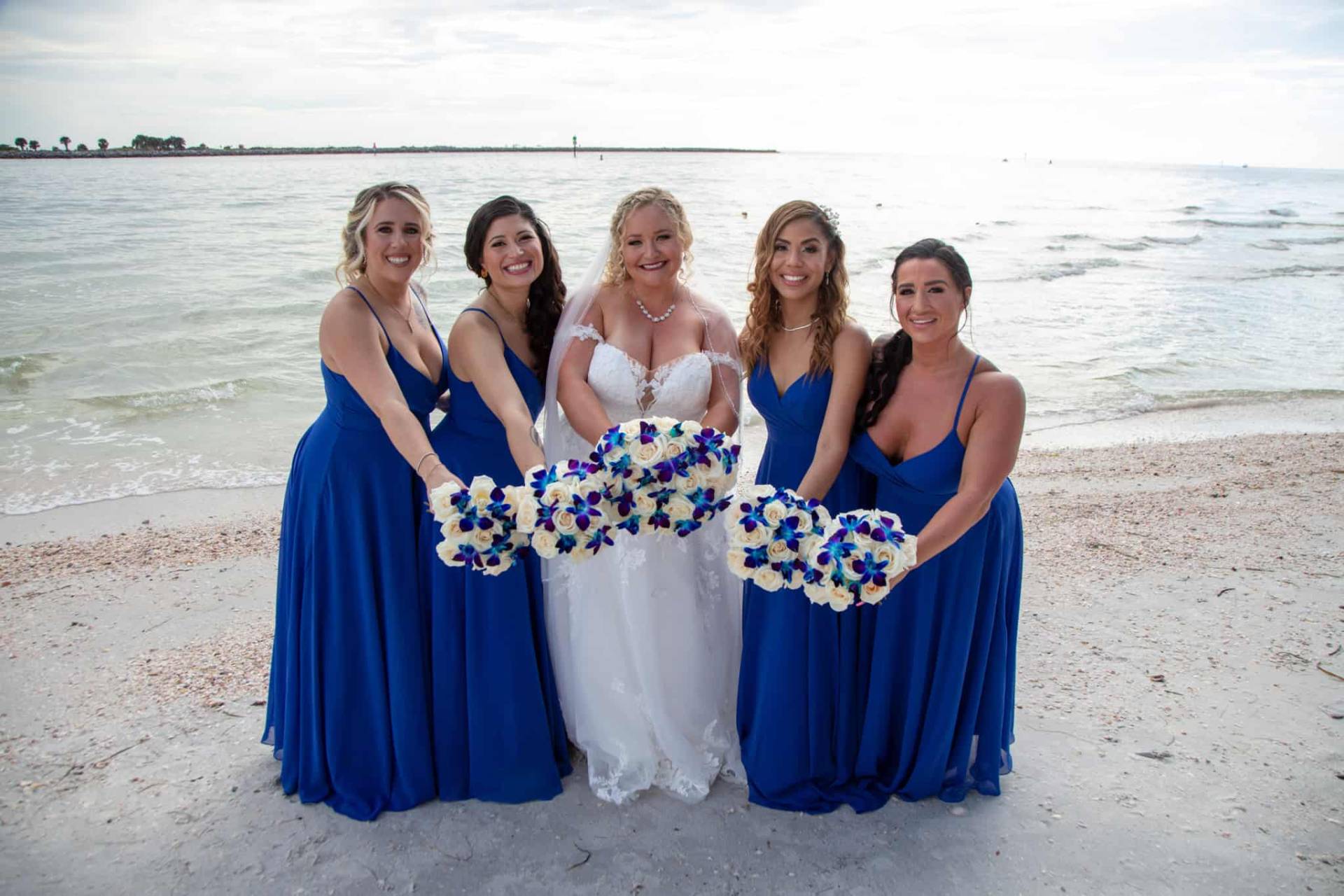 bride with her bridesmaids on the beach