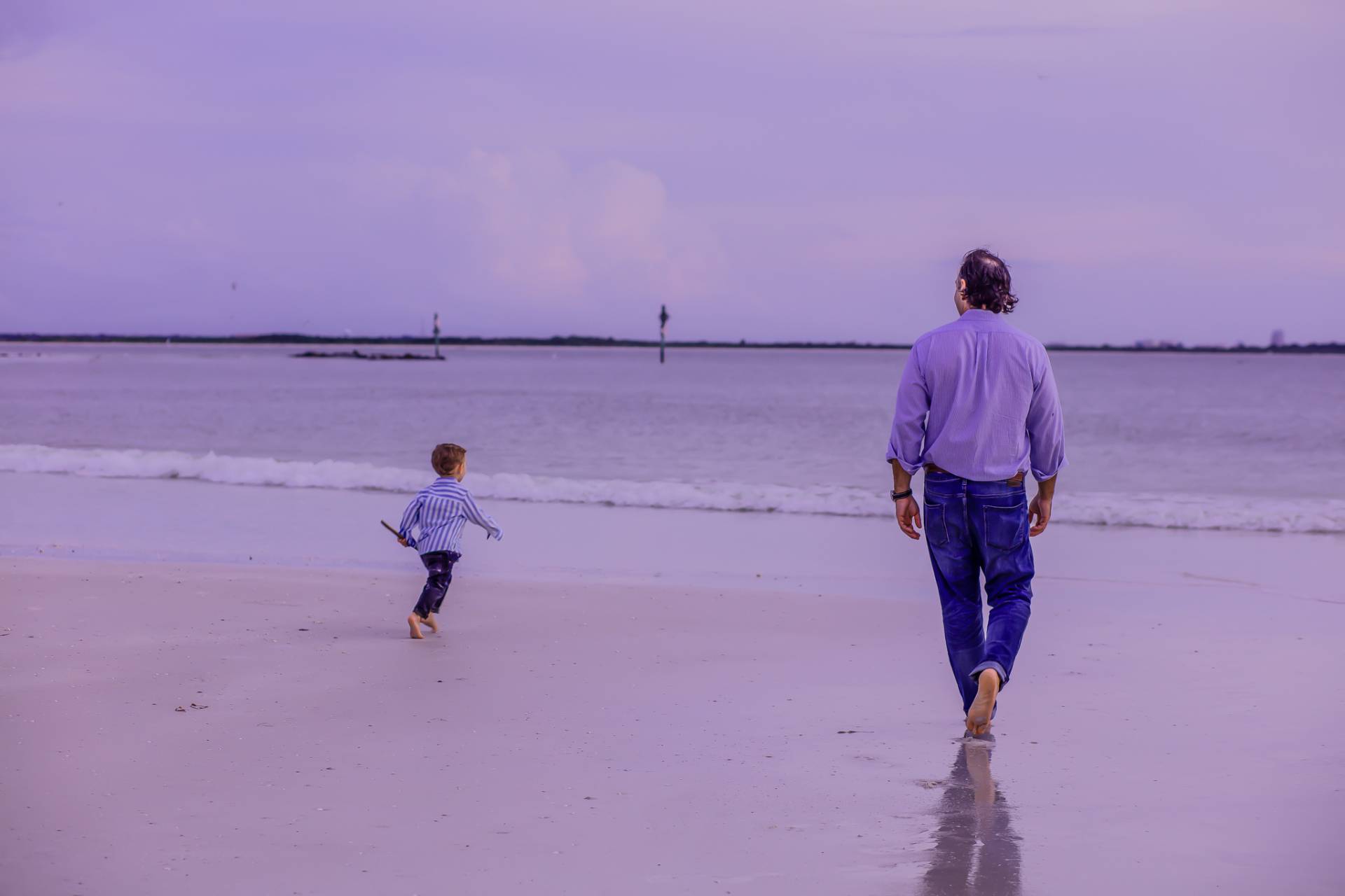 father and son on the beach at sunset