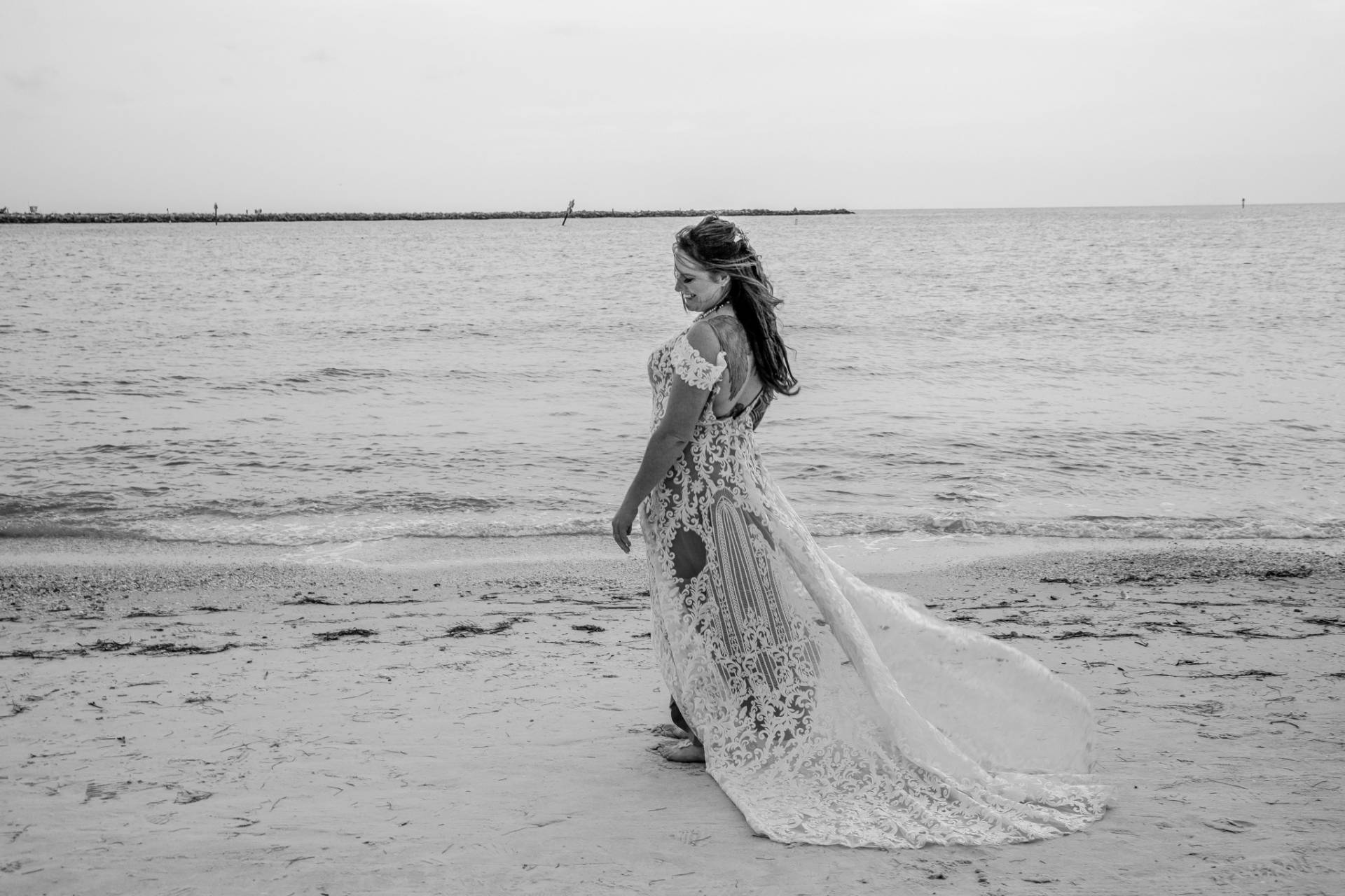 bride standing on the beach, black and white photo