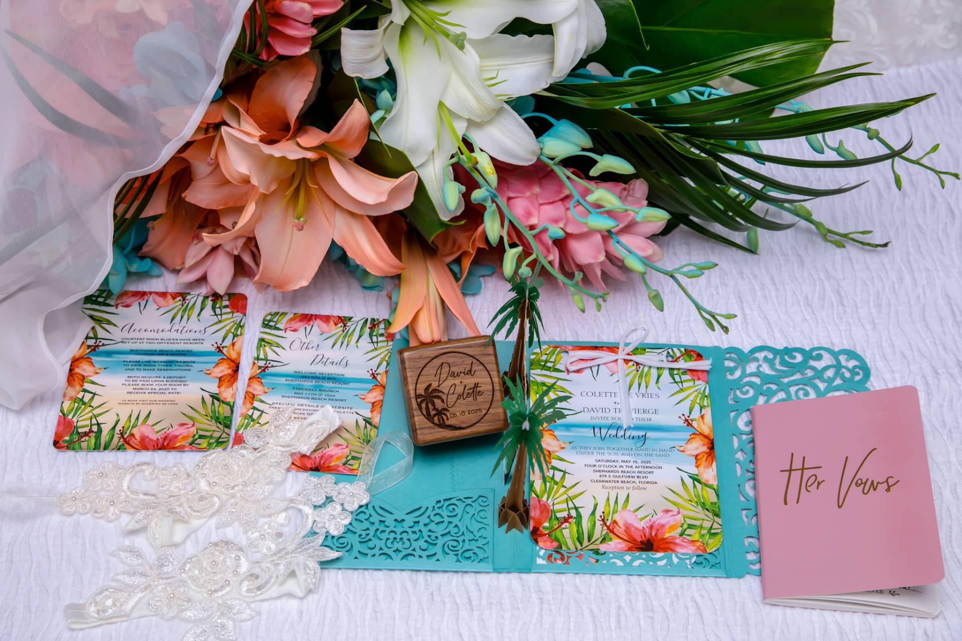 wedding invitation with vow book, flowers, ring box, and veil