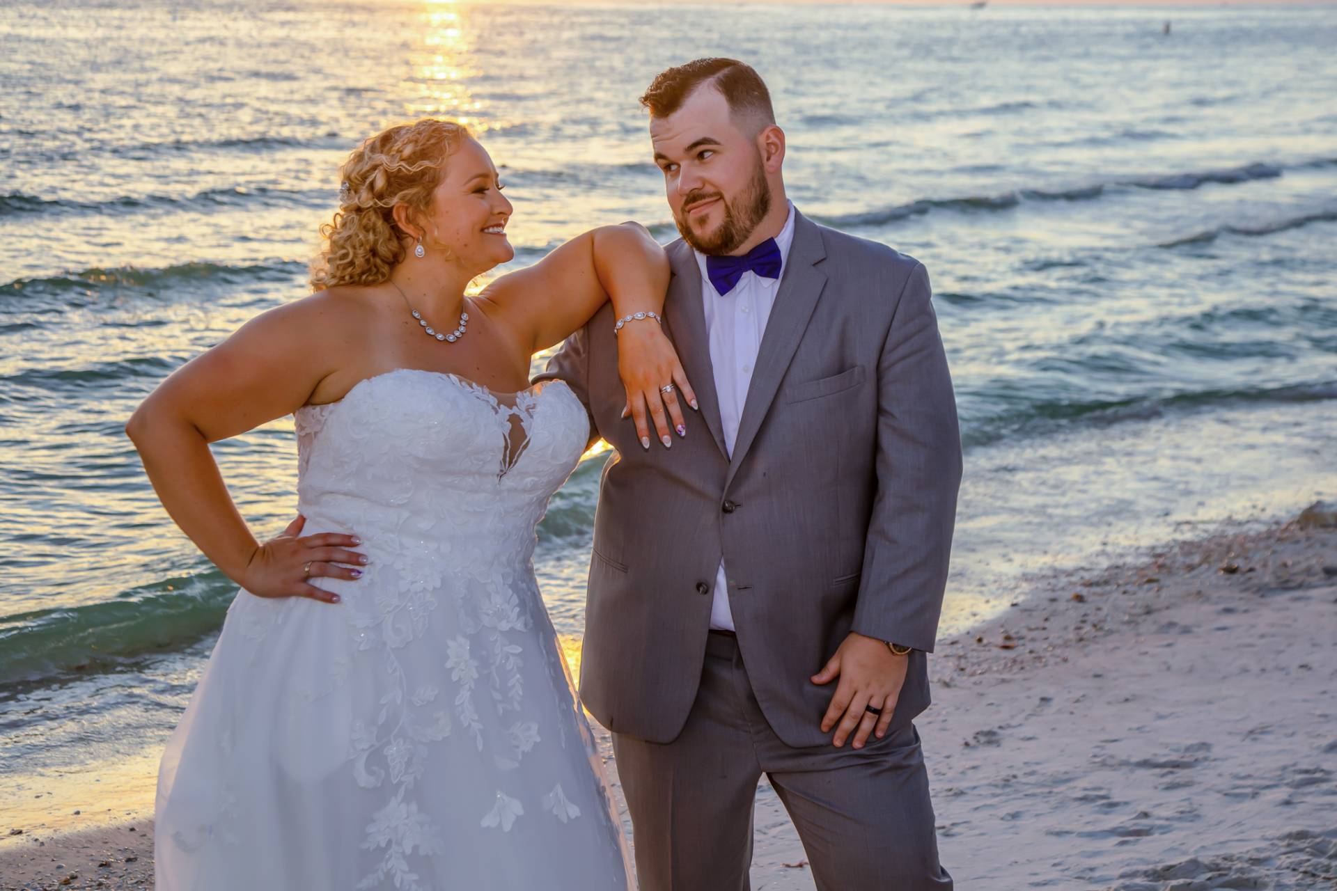 bride and groom looking at each other on the beach at sunset