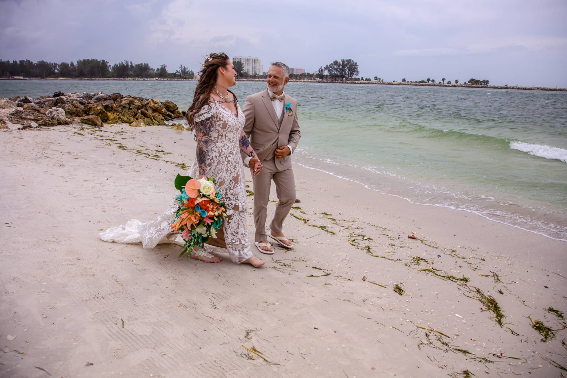bride and groom walking hand in hand on the beach