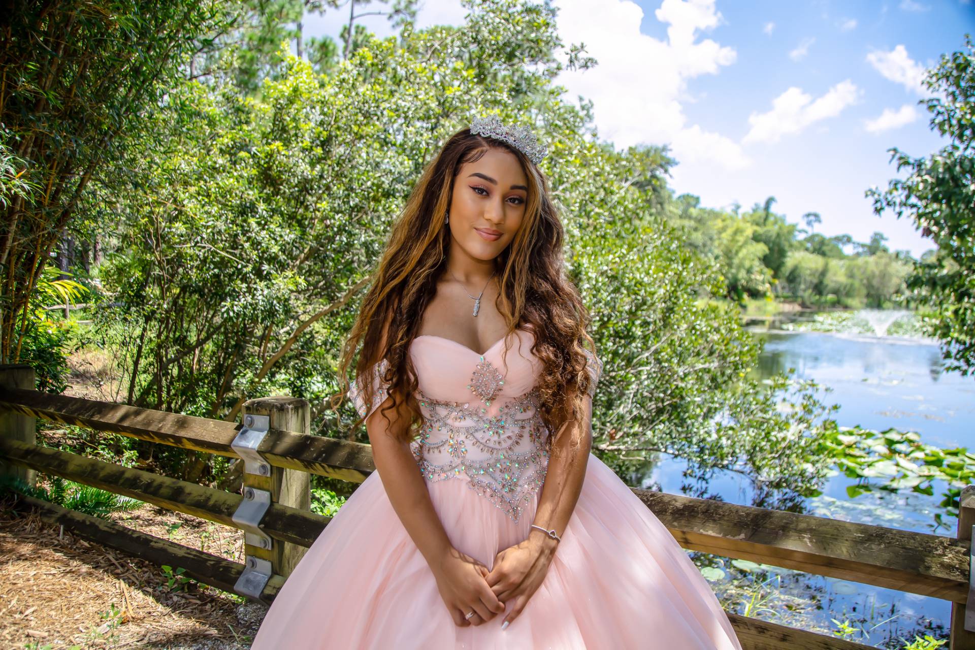 Quince girl in her pink dress at the park with lake in the background