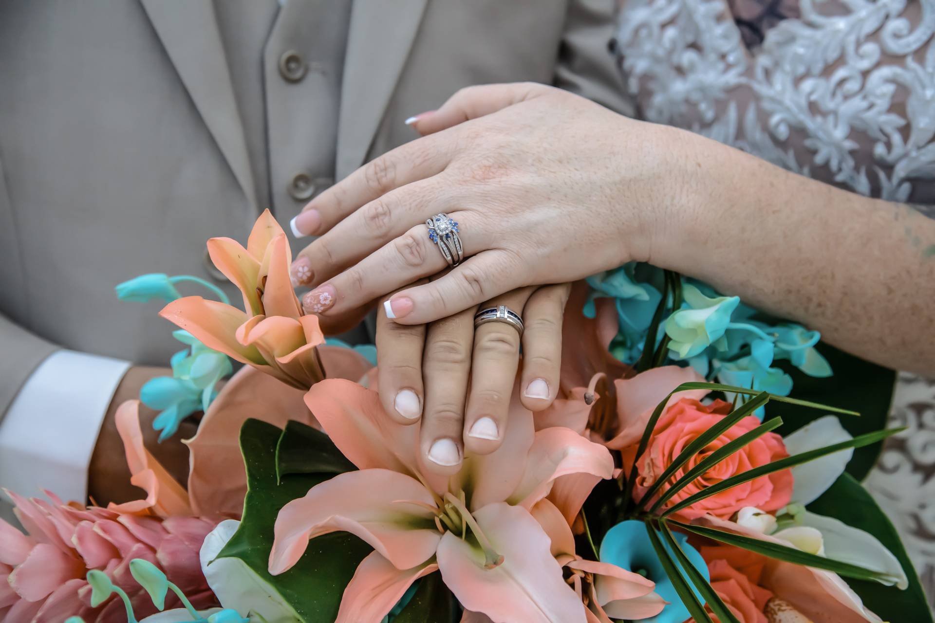 bride and grooms ring hands on top of her flowers